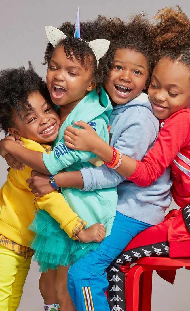 Four children of different ages crowded together, laughing.