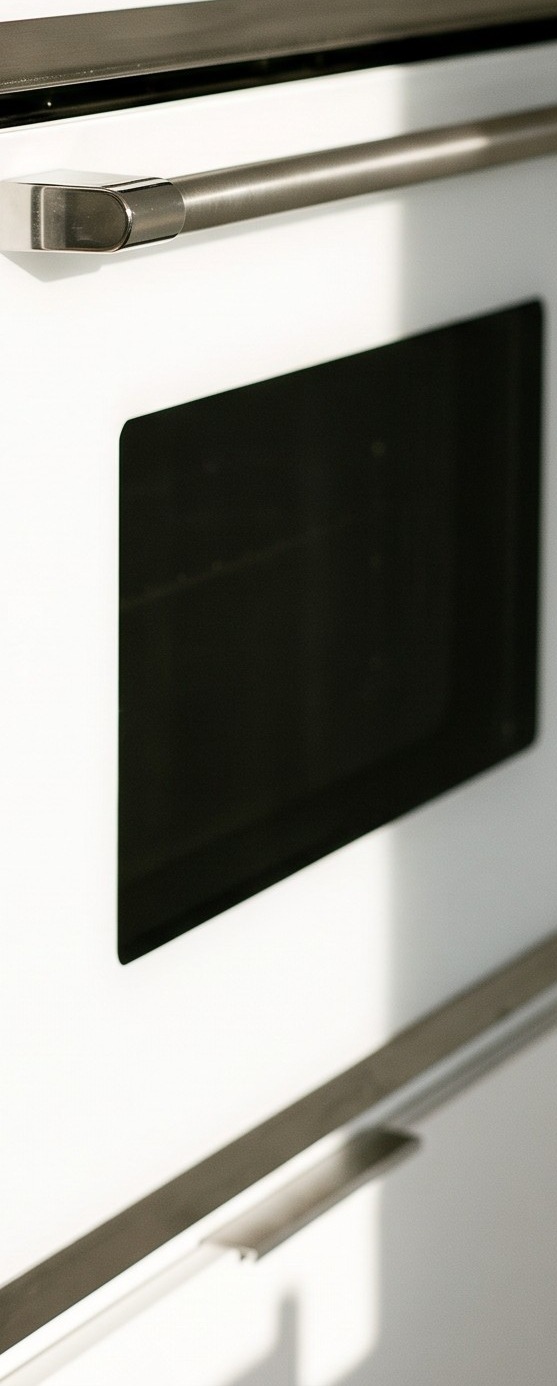 A white oven door with a steel handle and a glass window.